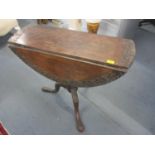 A Georgian oak pedestal swivel top table with carved decoration