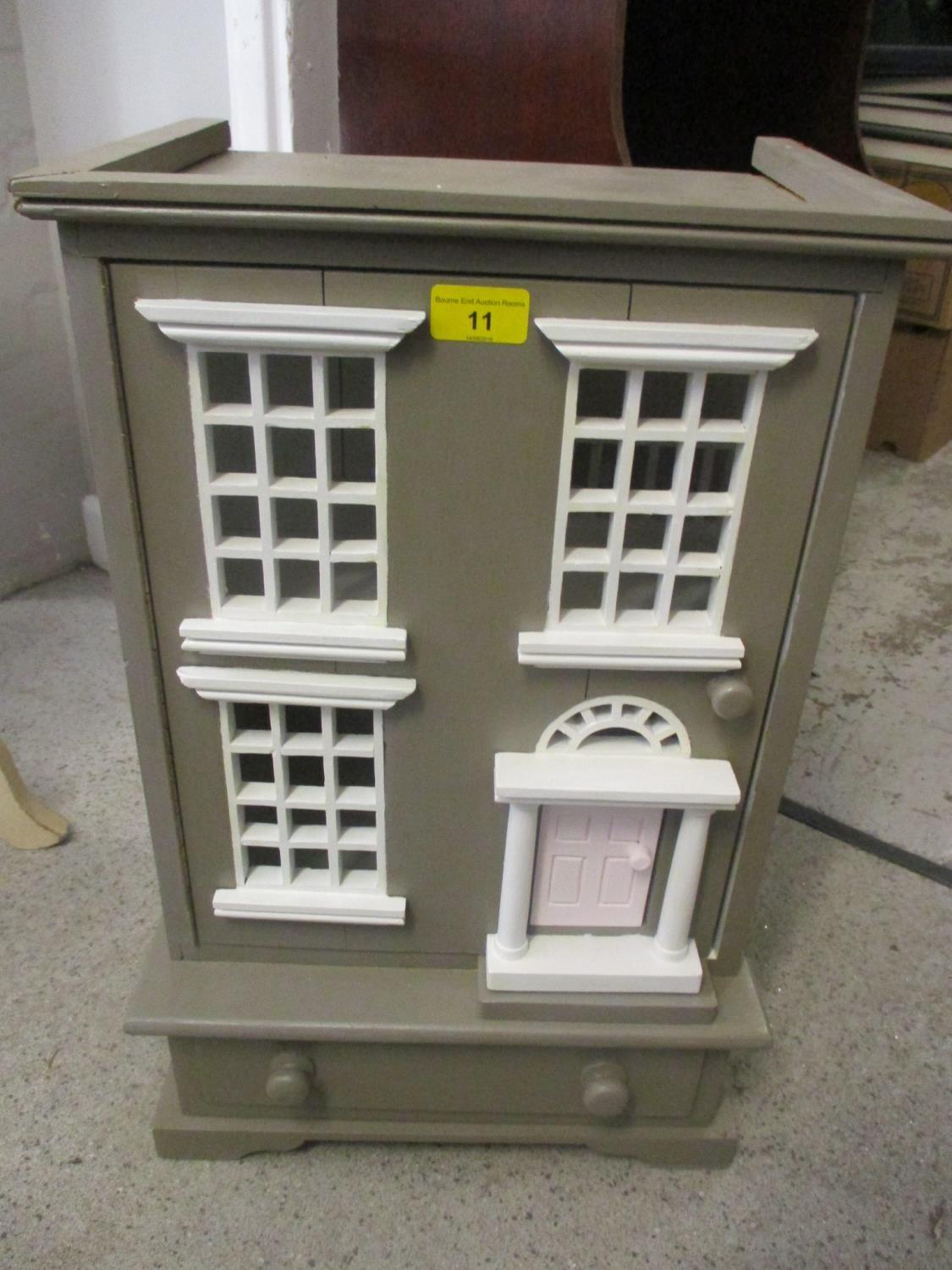 A small doll's house with drawers below