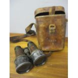 A pair of leather cased military issue binoculars