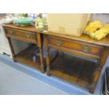 A pair of reproduction oak two tier lamp tables having single inset drawers