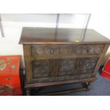 A mid 20th century Tudoric style carved oak side cabinet on stretchers