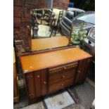 A mid 20th century oak dressing table having three central drawers flanked by two cupboard doors