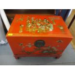 A modern Chinese red lacquered and painted chest with a hinged lid on a stand, decorated with