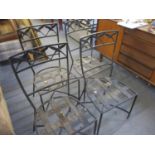 A set of four black, wrought iron outdoor chairs with lattice work seats