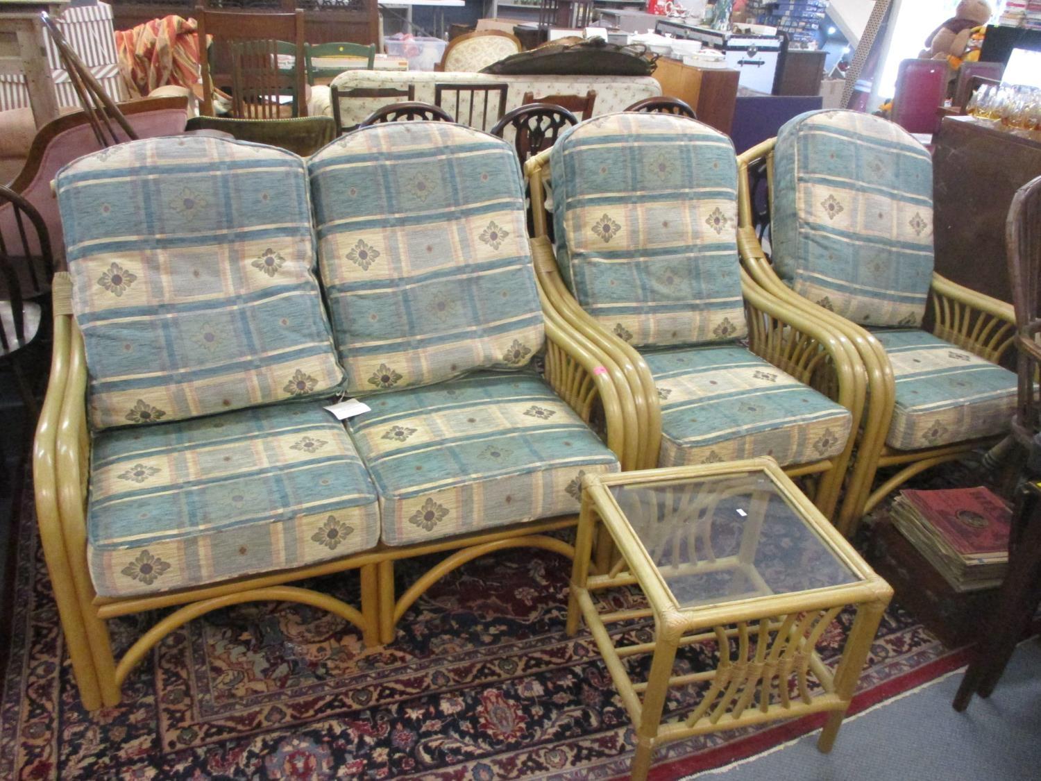 A cane conservatory two seater sofa, two armchairs and an occasional table