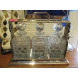 A silver plated Tantalus with three cut glass decanters. Condition: the lock and key require