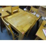 A modern light oak dining table, 30" h x 47" w and four ladder back, leather seated chairs