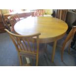 A Jack Christmas mid 20th century yew extending circular table with four walnut, spindle back chairs