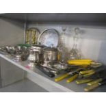 A mixed lot to include two cut glass decanters, silver plated trays, brass candlesticks, cutlery and