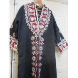 Circa 1980, a north African black Kaftan with embroidered collar, cuffs and central panel
