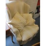 A cream striped wing back armchair with mahogany legs