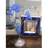 A contemporary silver coloured table lamp with four swirled blue glass flower head shaped shades,