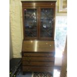 An Edwardian mahogany bureau bookcase having twin glazed doors above a fall flap and four drawers