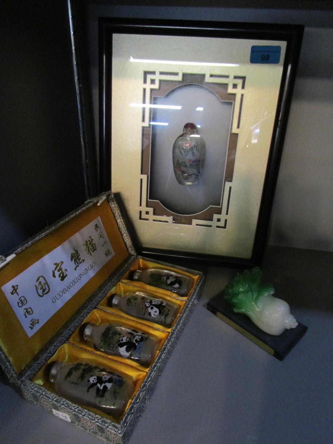 A Chinese framed and glazed glass snuff bottle, a boxed set of four Chinese glass snuff bottles