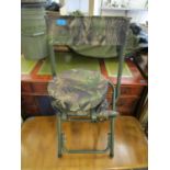 A modern folding chair with padded seat having camouflaged fabric