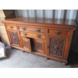 A late Victorian/early Edwardian walnut sideboard with two central drawers above cupboards,