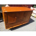 A mid 20th century light Ercol side cabinet having three cupboard doors and a drawer below 32"h x