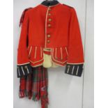 A Kings Regiment red regimental jacket with tartan sash, having Kings Regiment buttons (several