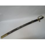 A WWI Russian sword with a carved wooden handle, brass pommel and knuckle guard, bearing text, in