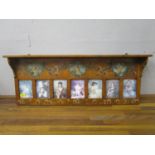 A late Victorian painted satinwood overmantle decorated with panels of putti and flowers with