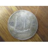 A Chinese dollar coin with Junk and Sun Yat-sen to the obverse