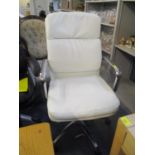 A modern cream leather upholstered swivel office chair, together with a light wood desk having two