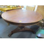 A 19th century mahogany pedestal dining table on paw feet and an early 20th century beech spindle