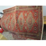 A machine made Royal Kesham carpet with medallions and a red ground, 78" x 112"