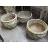 A pair of weathered composition stone garden planters with grape ornament, and a similar pedestal