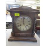 An early 20th century oak mantle clock having an 8 day movement and a silvered dial