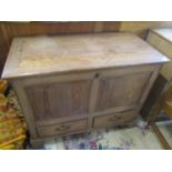 A 19th century pitch pine chest with a hinged top over a panelled front and two drawers, on