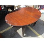 Circa 1910 an oval mahogany extending dining table with spare leaf and handle, fluted square,