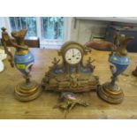 A late 19th century French mantle clock with two matching garnitures