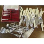 A mixed lot of cutlery to include silver sugar tongs, mother of pearl handled knives and other items