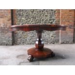 A Victorian rosewood breakfast table with a tip top, over a baluster, octagonal column and round