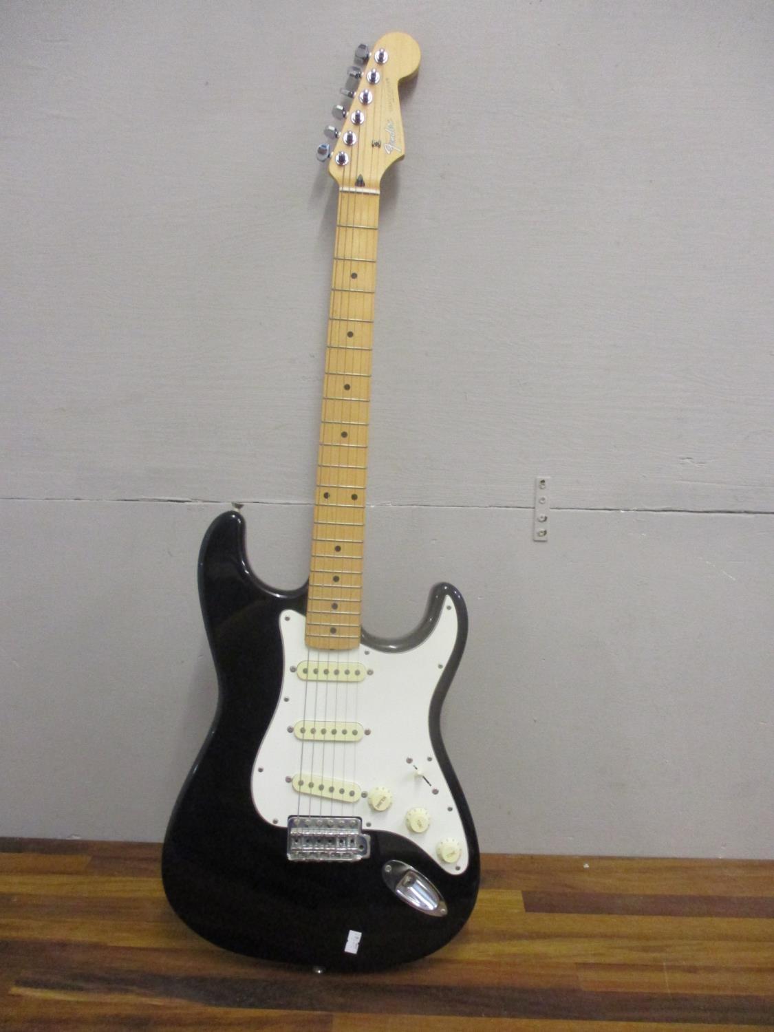 A Fender Stratocaster electric guitar in black and white, serial number T036123, made in Japan