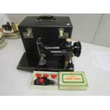 A Singer 221 compact sewing machine in case, together with a Singer attachment for a later model