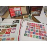 A large quantity of loose stamps and mixed tea cards and three folders of world stamps