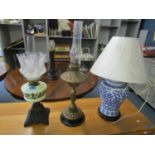 Two Victorian oil lamps, one with a cast iron base, a floral enamelled opaline reservoir and