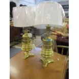 A pair of brass ring turned table lamps on a trefoil base, re-wired and pat tested with white shades