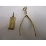 A 9ct gold ingot and a 9ct gold pendant in the form of a wish bone, total weight 14.29g