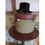 A vintage leather and canvas hat box containing a Tress and Co top hat, A/F