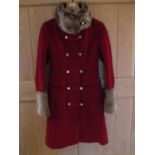 A modern Karen Millen knee length coat in deep red with faux fur collar and cuffs, ladies size UK 8