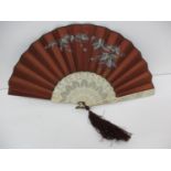 A mid 19th century fan, the chocolate brown silk leaf painted with trailing ivy, pierced sticks