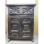 An adapted, mainly early oak and walnut cabinet with a thick plant top over a carved drawer and twin