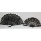 Two late 19th/early 20th century fans, one with a black gauze stained carved sticks and a black