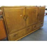 An Ercol light elm sideboard having three cupboard doors above two drawers, 30" x 51" x 17"