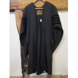 An Ede and Ravenscroft doctors black graduation gown with four stripes to the sleeve,