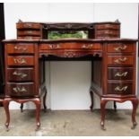 An early 20th century walnut, serpentine fronted desk, with a brass, galleried, mirrored back and