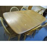 A light Ercol elm extending dining table with six matching Ercol elm and beech slat back dining